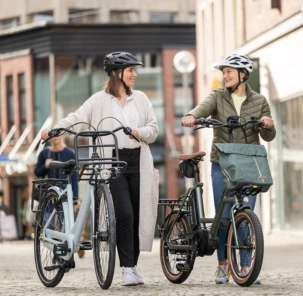Zwei RADWELT Mitarbeiter laufen mit ihren Kompakt E-Bikes durch Coesfelds Innenstadt.